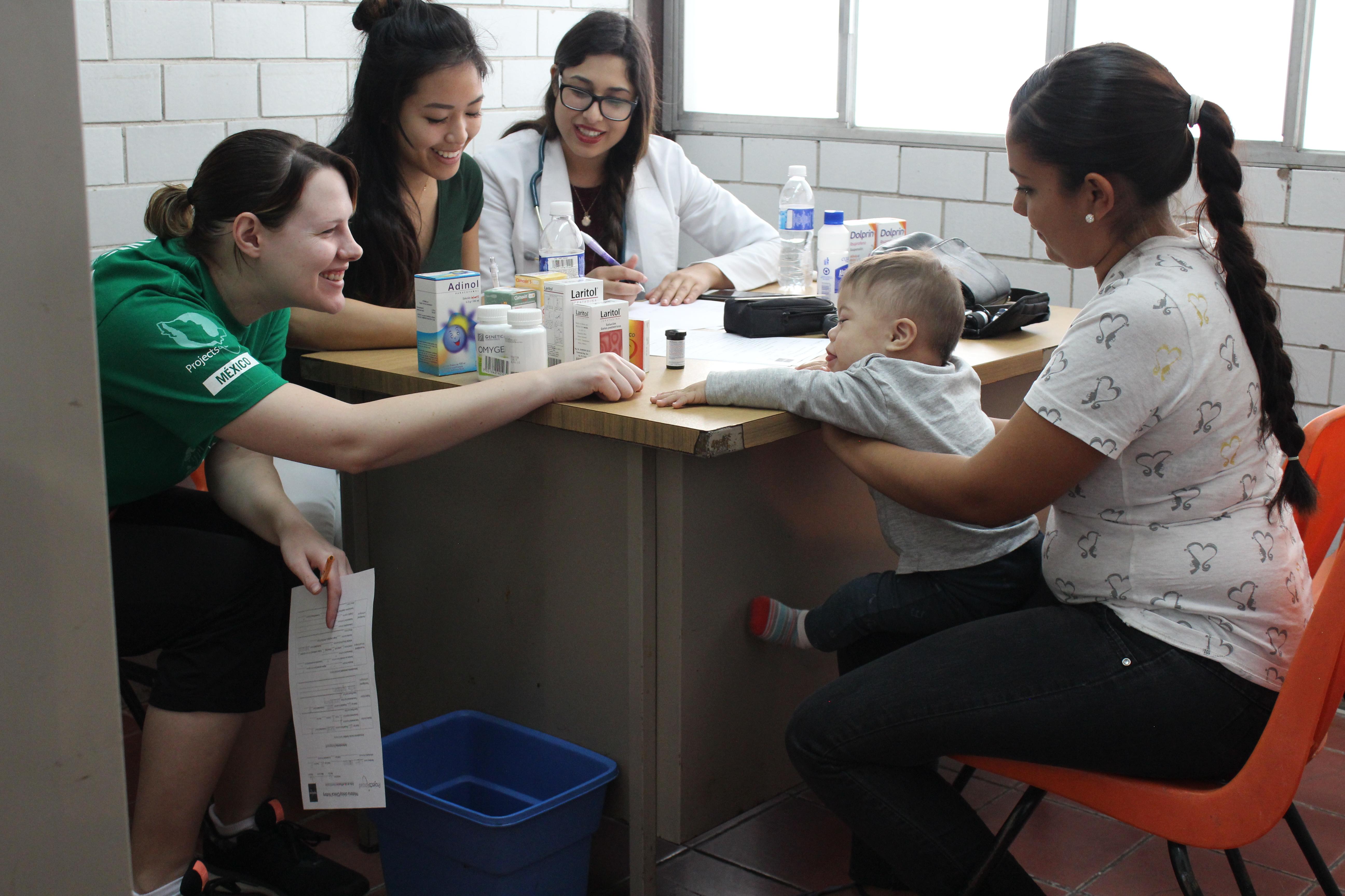 Projects Abroad female medical intern engaging with a young child during a check up whilst on her nursing internship in Mexico. A female intern from Projects Abroad is seen engaging with a young child during a check up whilst on her nursing internship in Mexico.